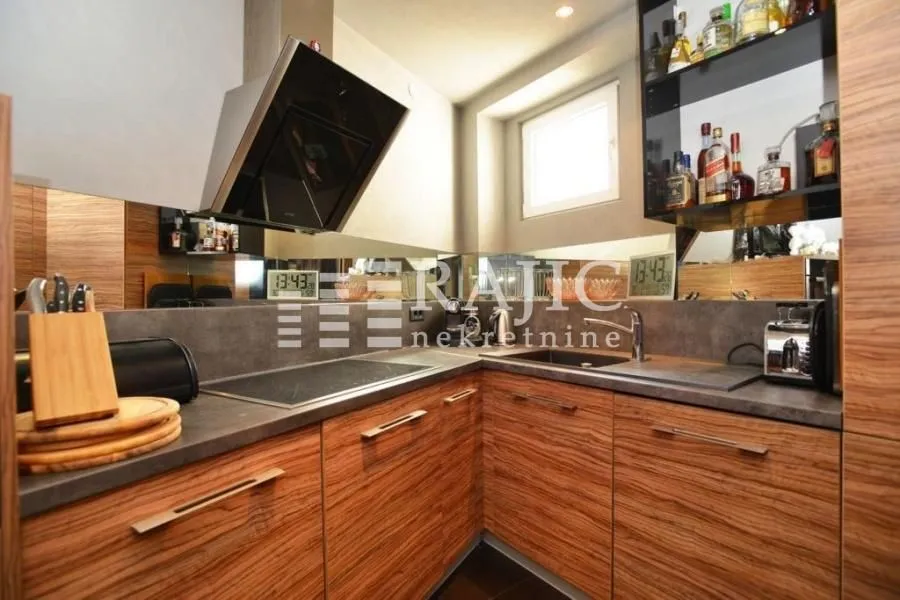 Modern kitchen with wooden elements and built-in appliances.