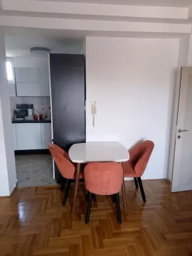 Trpezarijski sto sa narandžastim stolicama i pogledom na kuhinju. - image 3