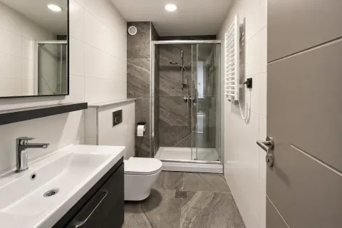 Moderno opremljeno kupatilo sa tuš kabinom, umivaonikom i WC šoljom. - image 4