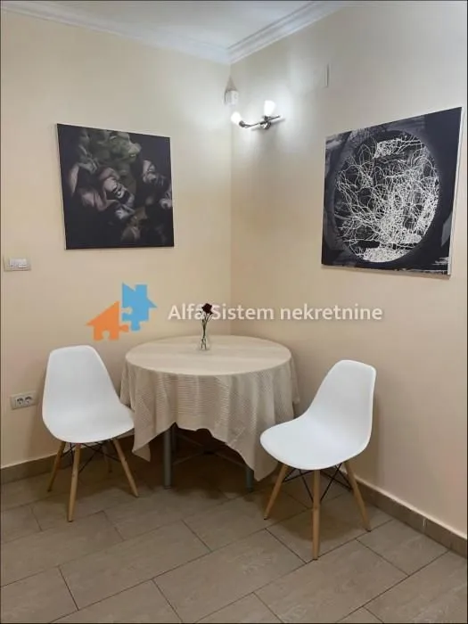 A small dining table with two chairs placed in the corner of the room.