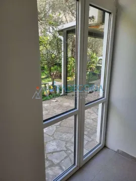 Pogled kroz balkonska vrata na dvorište i zelenilo. - image 2