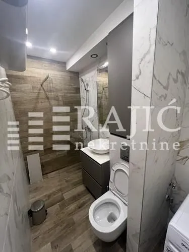 A modern bathroom equipped with a shower cabin and sanitary ware.