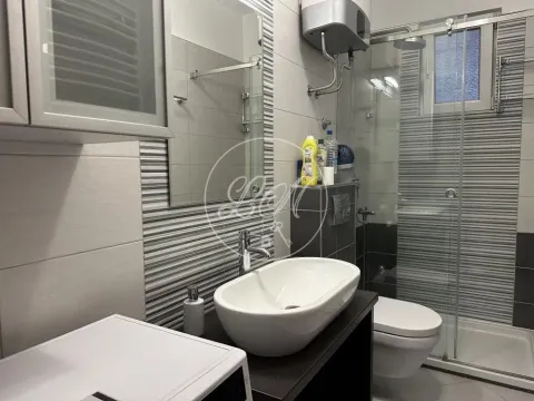 Modern bathroom with a shower cabin, washbasin, and toilet. - image 13