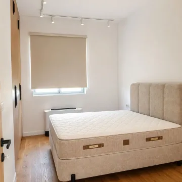 Bedroom with a double bed, wooden floor, and fitted wardrobe. - image 11