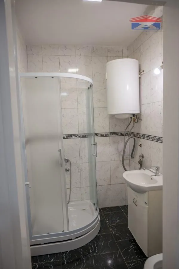 Kupatilo sa tuš kabinom, umivaonikom i bojlerom.