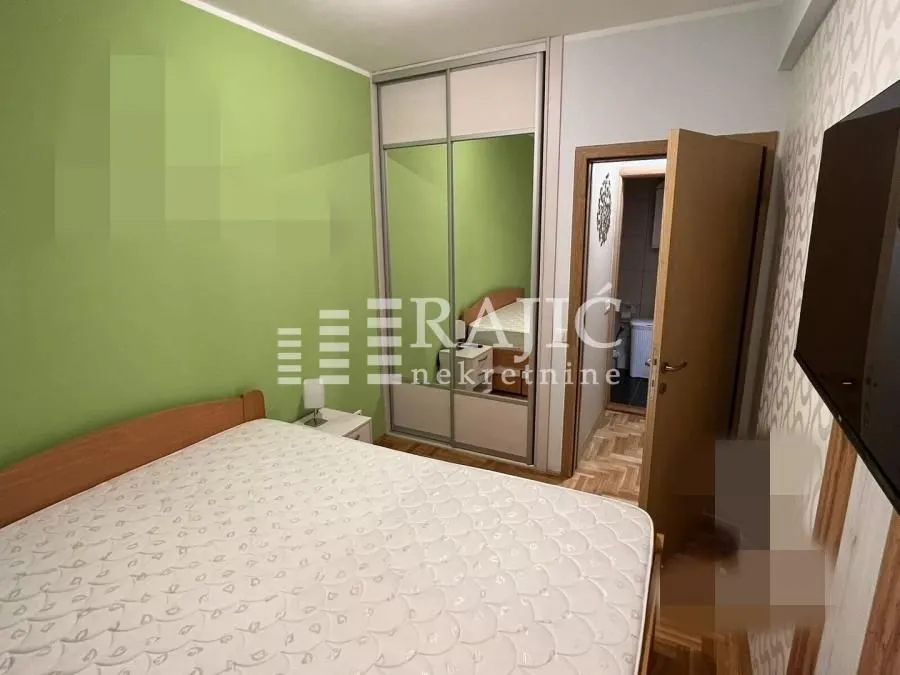 Furnished bedroom with a double bed and built-in wardrobe.