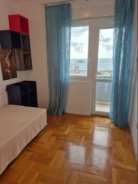 Namještena spavaća soba sa krevetom, policama i pogledom na more. - image 7