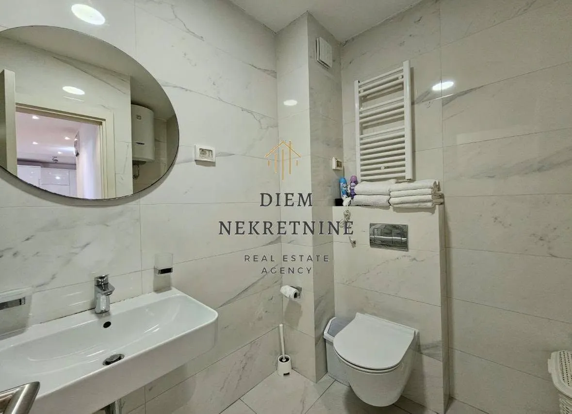 Moderne opremljeno kupatilo sa umivaonikom i wc šoljom.