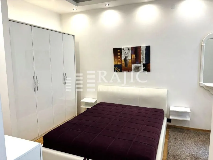 Furnished bedroom with a double bed and built-in wardrobe.