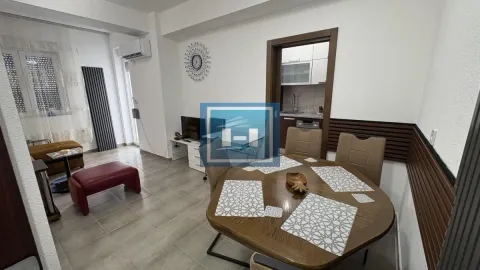 Living room with a dining table and a view of the kitchen in the background. - image 3
