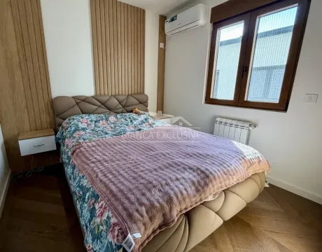 Nameštena spavaća soba sa bračnim krevetom i drvenim zidnim panelima. - image 11