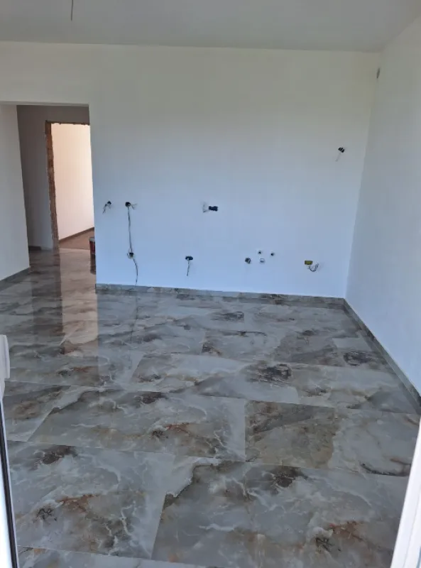 Empty unfurnished room with ceramic tile flooring and white walls.