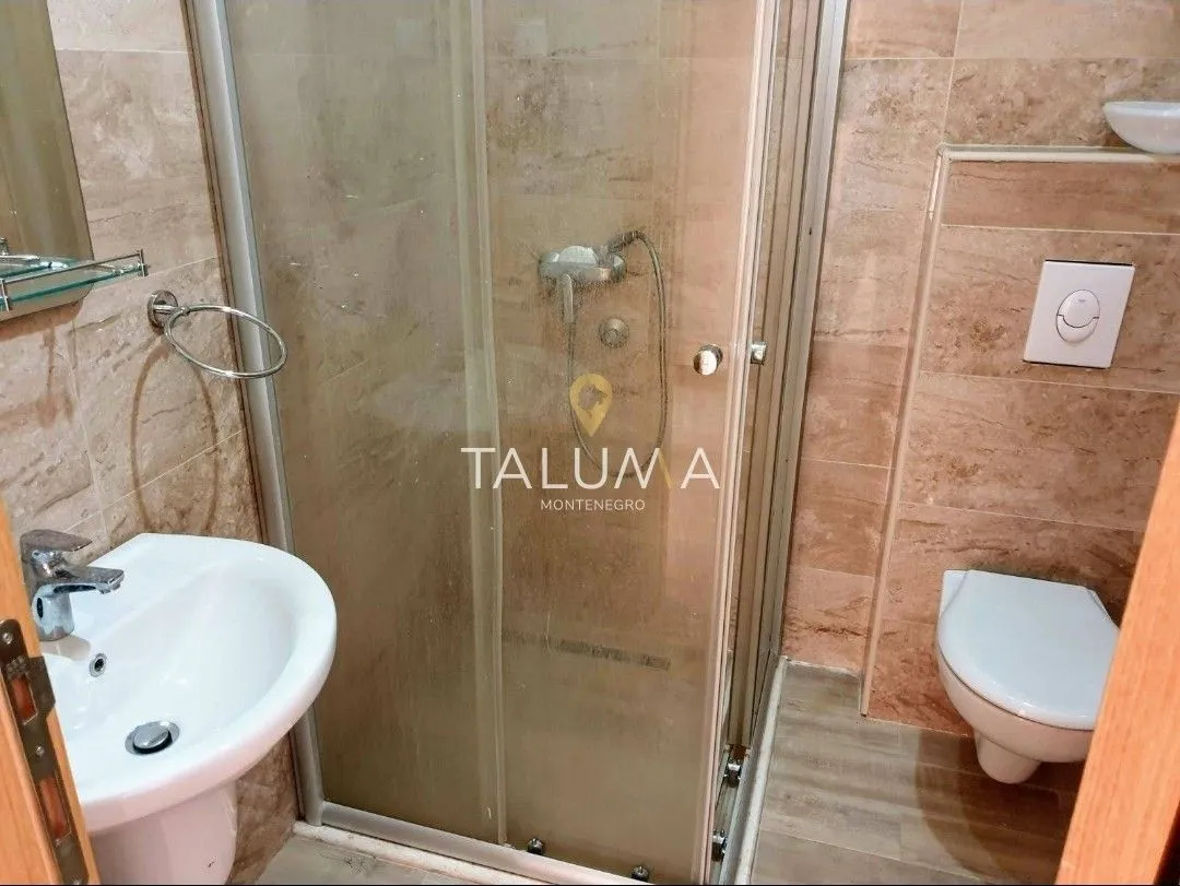 Kupatilo opremljeno tuš kabinom, umivaonikom i toaletom.