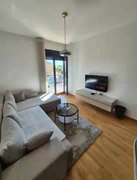 Dnevna soba sa garniturom, televizorom i izlazom na terasu. - image 2