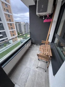 Manji namešteni balkon sa stolom i dve stolice i pogledom na okolne zgrade. - image 19