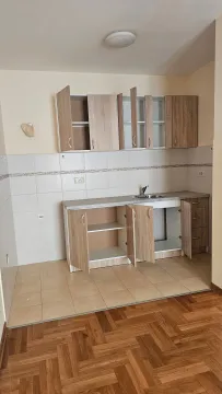 Prazna kuhinja sa drvenim elementima i sudoperom. - image 6