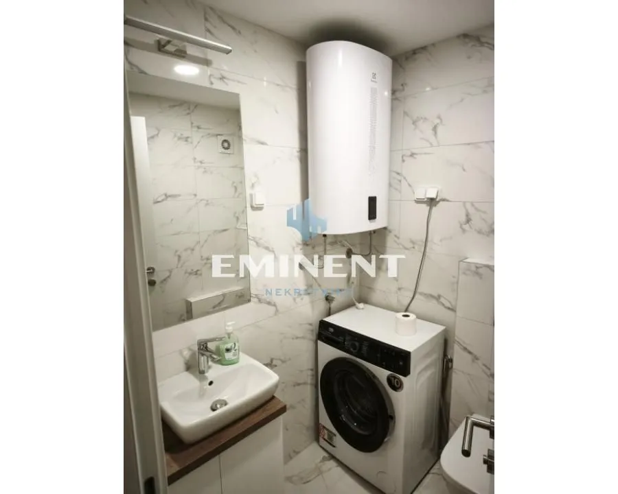 Bathroom equipped with a washbasin, washing machine, and water heater.
