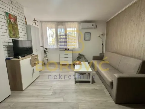 Dnevna soba sa garniturom za sedenje, televizorom i prozorom. - image 3