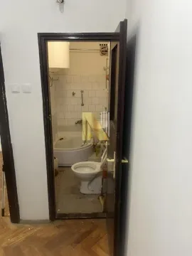 Pogled iz hodnika na starije opremljeno kupatilo kroz otvorena vrata. - image 7