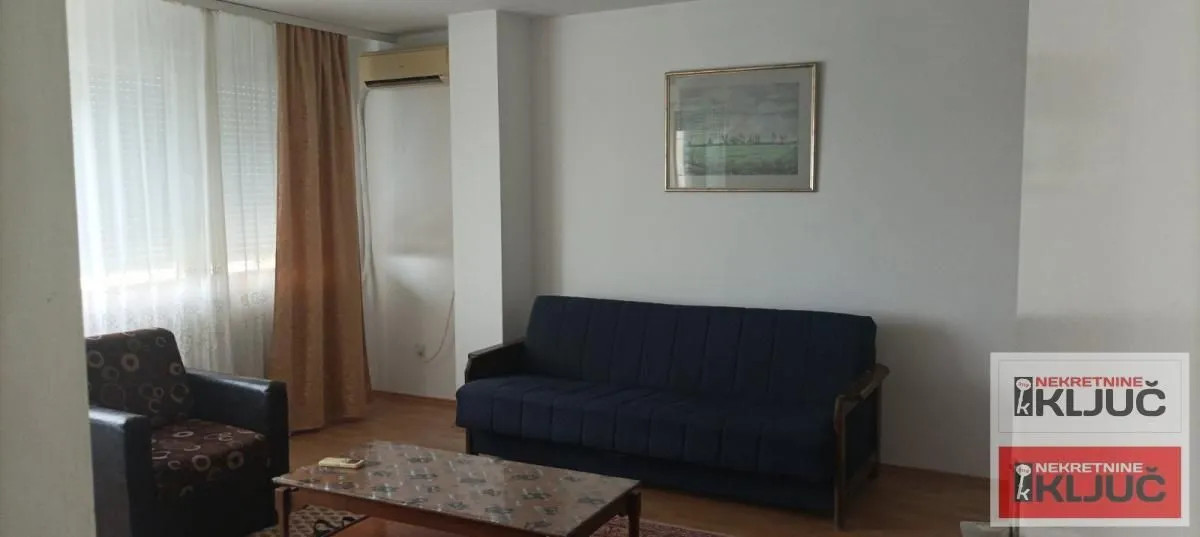 Dnevna soba sa kaučem, foteljom i stočićem.