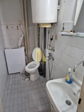 Starije opremljeno kupatilo sa WC šoljom, umivaonikom i mašinom za veš. - image 6