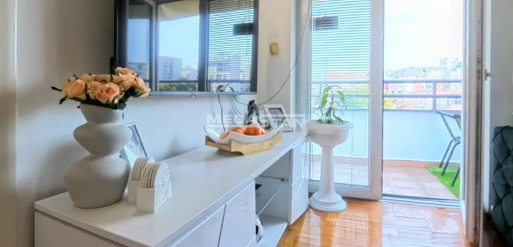 Dnevna soba sa televizorom i izlazom na terasu.
