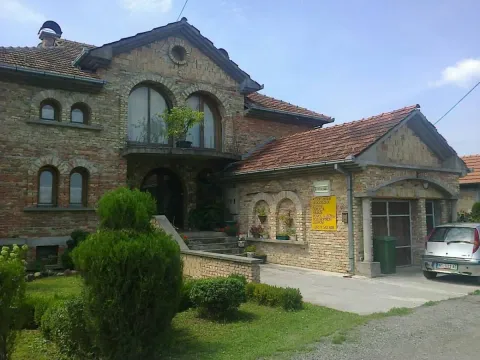 Prednji deo kuće sa dvorištem, fasadom od cigle i garažom. - image 6