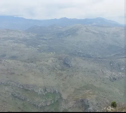 Panoramski pogled na brdoviti pejzaž i planine u daljini. - image 3