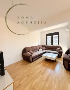 Living room with a corner sofa, coffee table, and hardwood flooring. - image 4