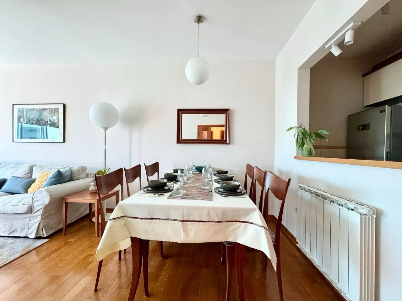 Spacious dining area with a set table and a view of the living room.