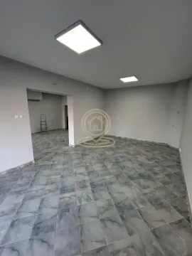 Empty room with tiled flooring and ceiling lighting under renovation. - image 3