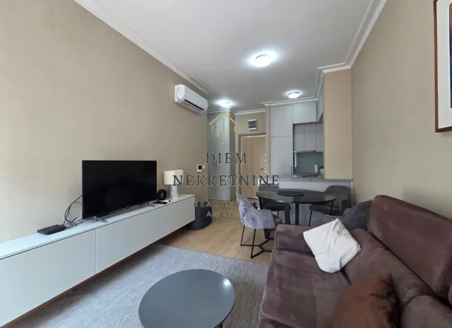 Living room with sofa, TV, and dining area.