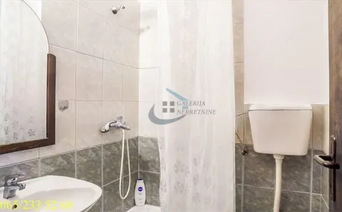 Smaller bathroom with a shower cabin, washbasin, and toilet. - image 5