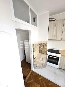 Smaller kitchen with light wooden cabinets and a white stove. - image 8