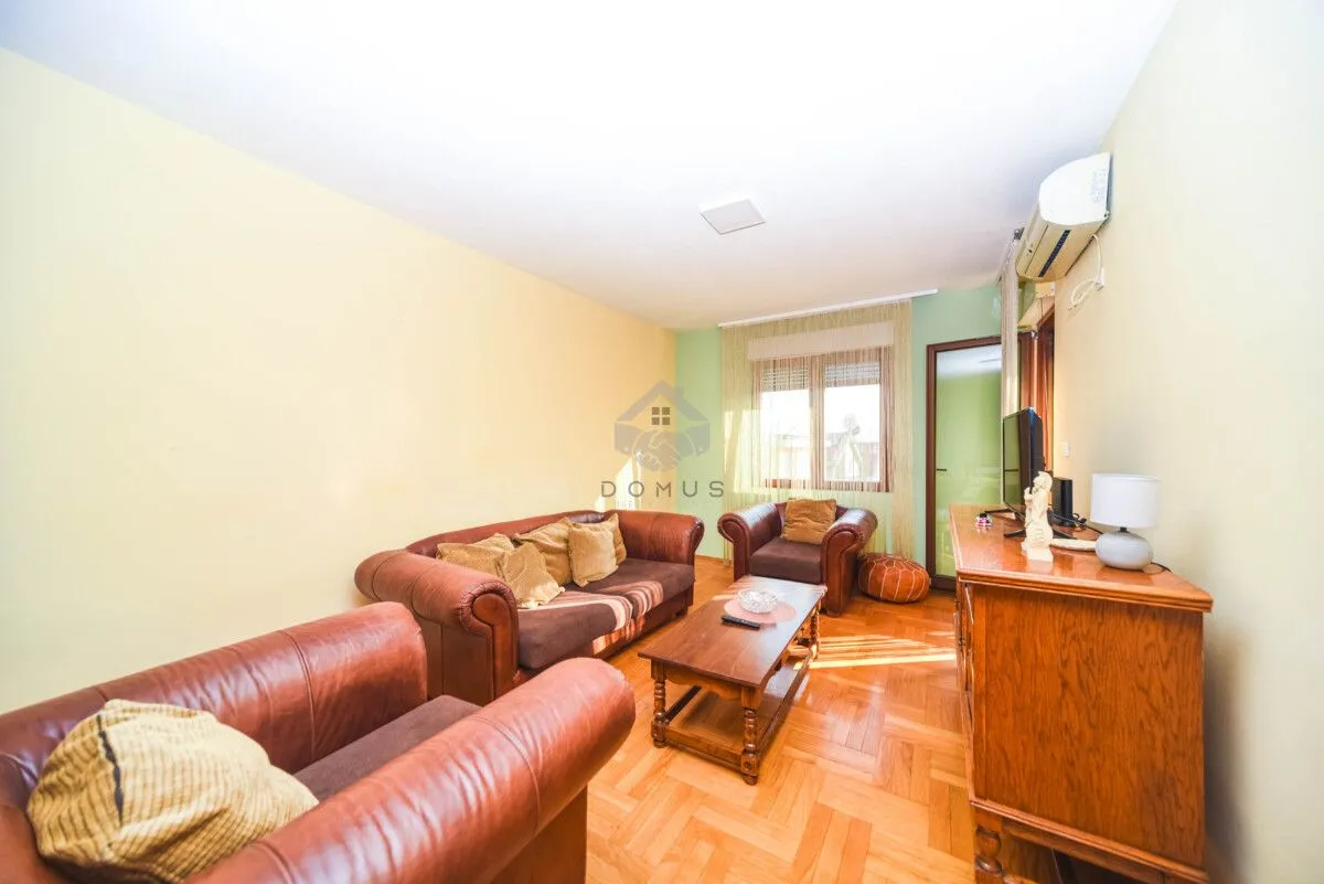 Living room with leather sofas, a wooden coffee table and a chest of drawers.