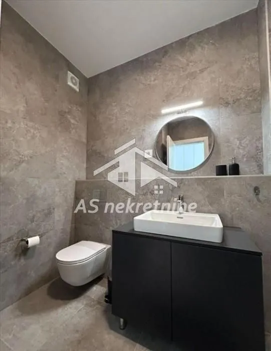 Modern bathroom equipped with a washbasin, cabinet, and toilet.