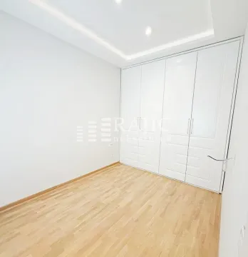 Empty bedroom with a built-in wardrobe and parquet flooring. - image 12