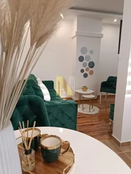 Dnevna soba sa zelenom garniturom i stočićem u prvom planu. - image 7