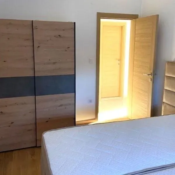 Bedroom with a bed, wardrobe, and an open door.