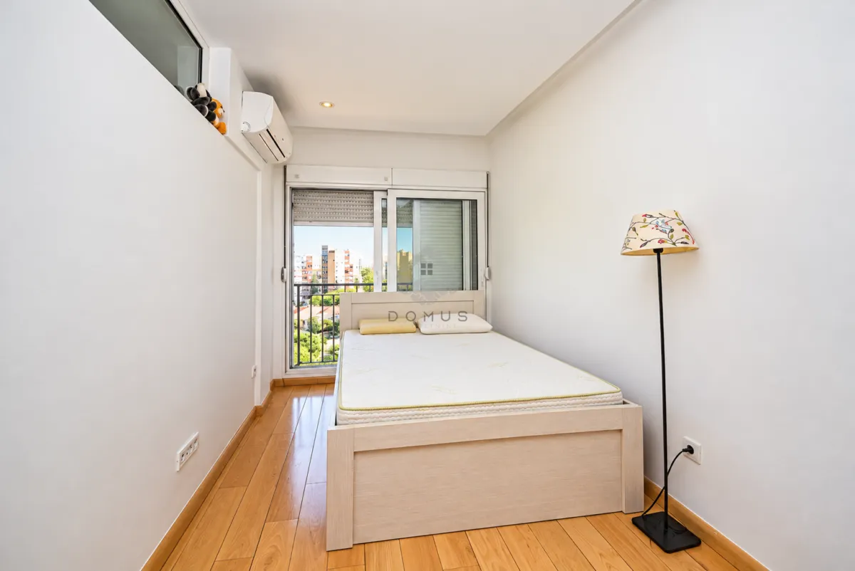 Small bedroom with a bed, wooden flooring, and access to the terrace.