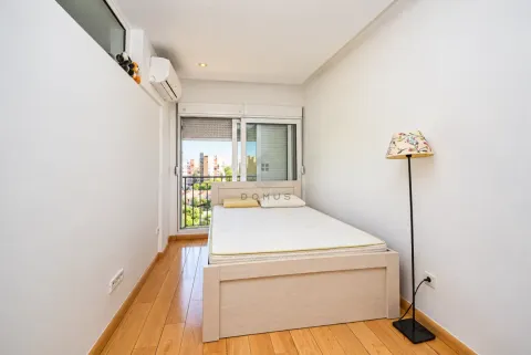 Small bedroom with a bed, wooden flooring, and access to the terrace. - image 6