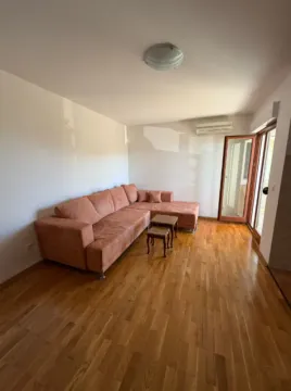 Dnevna soba sa ugaonom garniturom i drvenim podom. - image 4