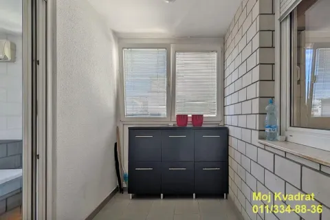 Enclosed balcony with a chest of drawers and windows with blinds. - image 12