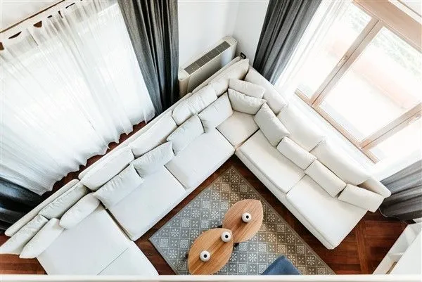 Bright living room with a large white corner sofa viewed from above.