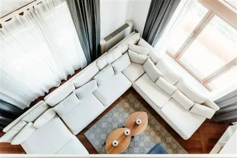 Bright living room with a large white corner sofa viewed from above. - image 30