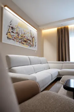 Modern living room with a sectional sofa and artwork on the wall. - image 4