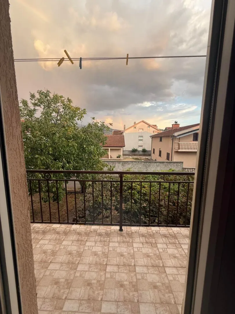 Pogled sa terase na dvorište i okolne kuće.