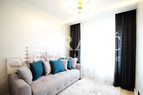Living room with a comfortable sofa and a large window with dark curtains. - image 2