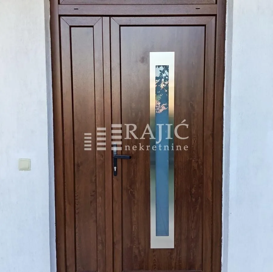 Front entrance door of the house with an agency logo.