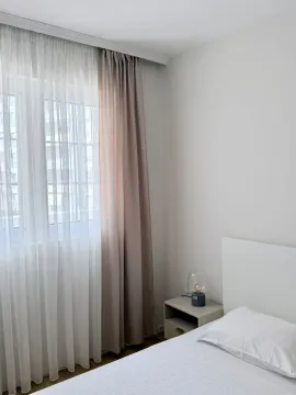 Bright bedroom with a bed and a nightstand by the window. - image 3